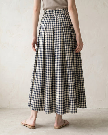 The Delphine skirt in navy and white grid — front three-quarter view on model