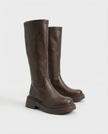 The Elara Slim Riding Boots in brown — knee-high riding boots, angled view