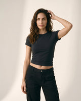 Model wearing black cropped crew-neck tee, arm raised front view – Moriel Heritage