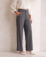 The Elin Wide Leg Tailored Pants in dark gray — wide-leg suit trousers with hand in pocket, front view on model