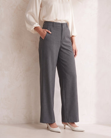 The Elin Wide Leg Tailored Pants in dark gray — wide-leg suit trousers with hand in pocket, front view on model