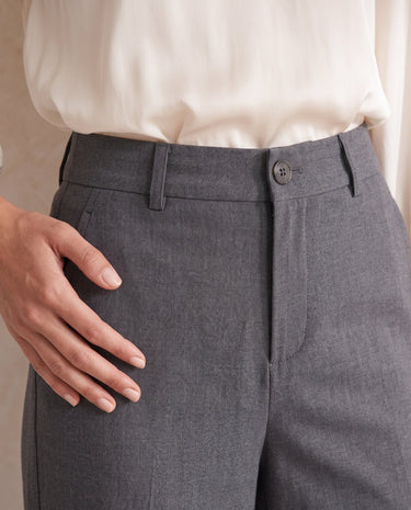 The Elin Wide Leg Tailored Pants in dark gray — close-up of button waist and pocket