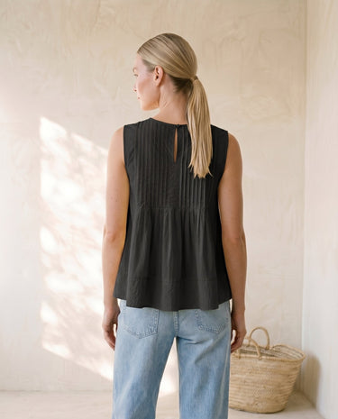 The Elio Pleat Vest in black — pleated swing top, back view on model