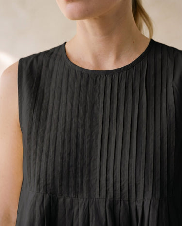 The Elio Pleat Vest in black — close-up of pin-tuck pleated neckline