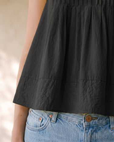 The Elio Pleat Vest in black — close-up of pleated hem