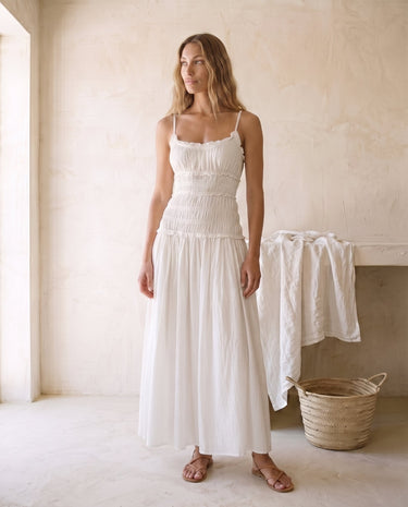 The Elire Dress in white — shirred bodice tiered maxi dress with straps, front view on model