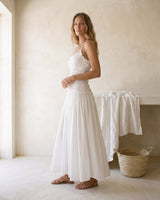 The Elire Dress in white — shirred maxi dress with tiered skirt, side view on model