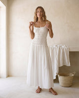The Elire Dress in white — shirred maxi dress with tiered skirt, front view on model