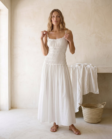 The Elire Dress in white — shirred maxi dress with tiered skirt, front view on model