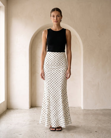 The Elisia Polka Dot Skirt in white — polka dot fishtail maxi skirt, front styling view on model