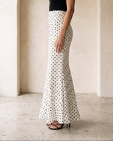 The Elisia Polka Dot Skirt in white — polka dot fishtail maxi skirt, side view on model