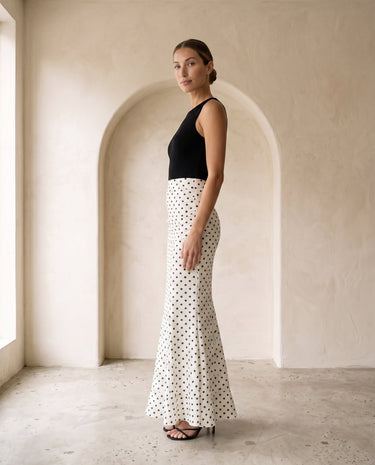 The Elisia Polka Dot Skirt in white — polka dot fishtail maxi skirt, side view on model