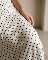 The Elisia Polka Dot Skirt in white — close-up of ruched hip and black polka dot fabric