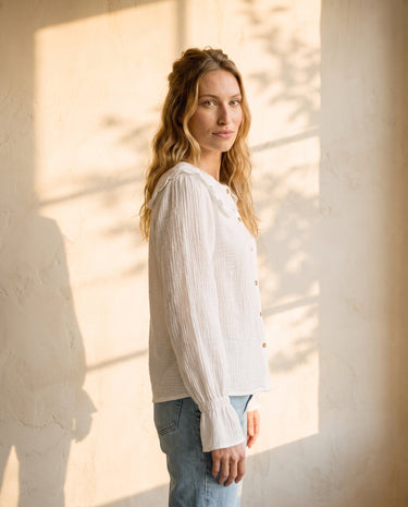 The Elodie Cotton Ruffle Collar Blouse in white — ruffle-collar blouse, side view on model