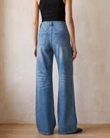 The Elodie jeans in blue — back three-quarter view on model