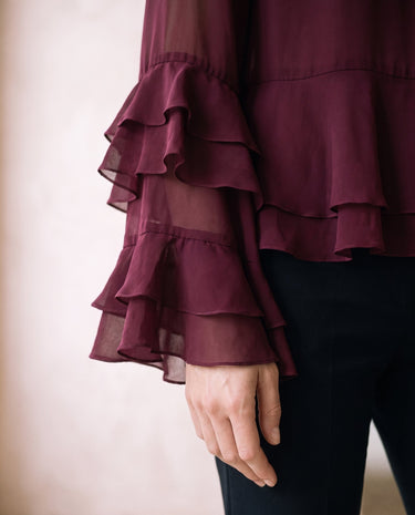 The Eloise Ruffle Blouse in burgundy — close-up of tiered ruffle bell sleeve