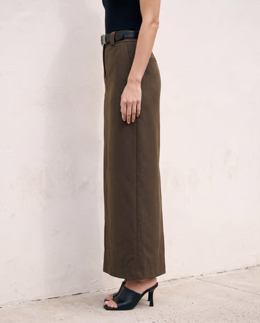 The Eloise Tailored Skirt in brown — straight maxi skirt, side view on model