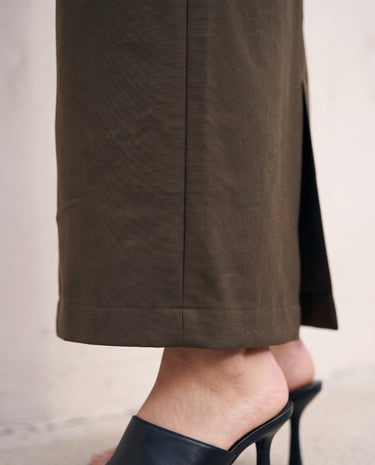 The Eloise Tailored Skirt in brown — close-up of front slit and hem