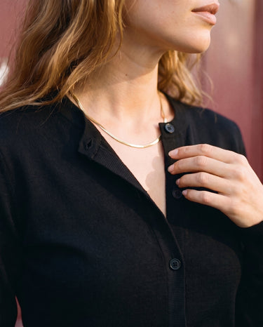 The Elsa Cardi in black — close-up of the button placket and neckline
