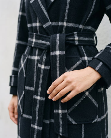 The Emilia Grid Longline Coat in black windowpane check — close-up of tie belt and pocket detail