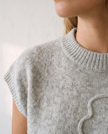 The Floral Embroider Top in light gray — close-up of ribbed mock neckline and shoulder