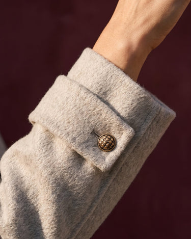 The Georgia Wool Coat in beige — close-up of the buttoned cuff detail