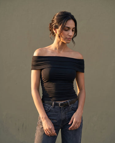 Model wearing black off-shoulder top with jeans, full front view – Moriel Heritage