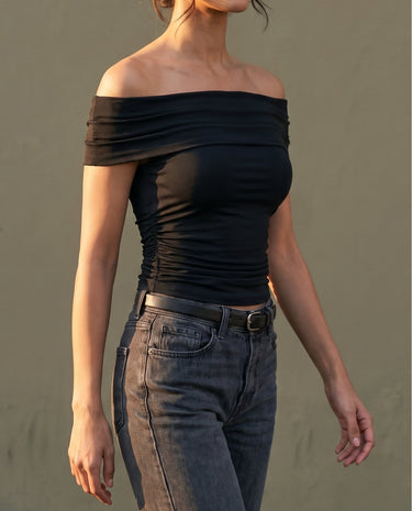 Model wearing black off-shoulder top, three-quarter side view – Moriel Heritage