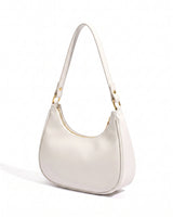 The Ines Crescent Bag in white, three-quarter studio view showing the half-moon silhouette and gold-tone hardware
