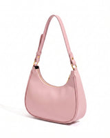 The Ines Crescent Bag in pink, three-quarter studio view showing the half-moon silhouette and gold-tone hardware