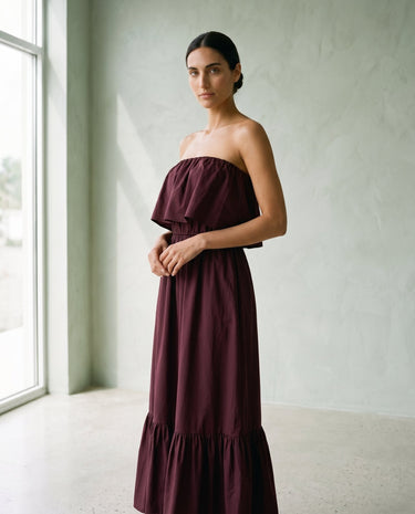 The Ivy Maxi in burgundy — strapless tiered maxi dress, three-quarter side view on model
