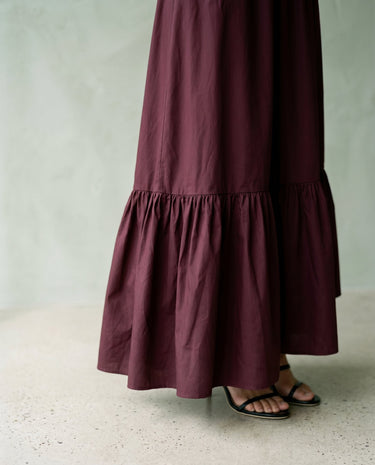 The Ivy Maxi in burgundy — close-up of tiered ruffle hem and flowing A-line skirt