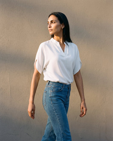 Model walking in the white blouse and jeans, three-quarter view – Moriel Heritage