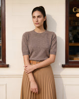 The Kyla short-sleeve knit tee in taupe — front view with arms crossed on model