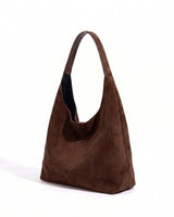 The Léa Slouch Tote in coffee suede, three-quarter studio view on a white background