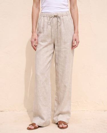 The Loelia Linen Pants in natural linen — wide-leg linen trousers, front view on model