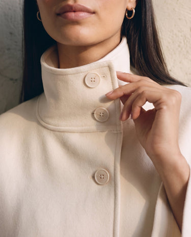 The Lorenne coat in white — close-up of the high collar and buttons