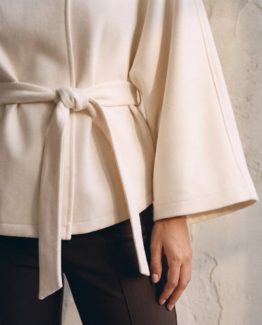 The Lorenne coat in white — close-up of the belted waist