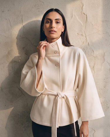 The Lorenne coat in white — front three-quarter view on model