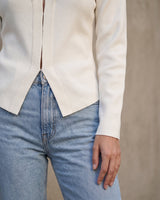 The Maisonette Cardigan in white — close-up of the curved hem and front opening