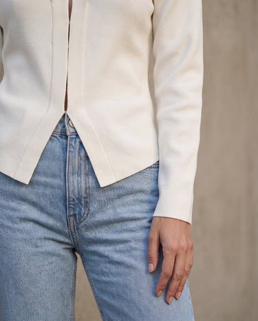 The Maisonette Cardigan in white — close-up of the curved hem and front opening