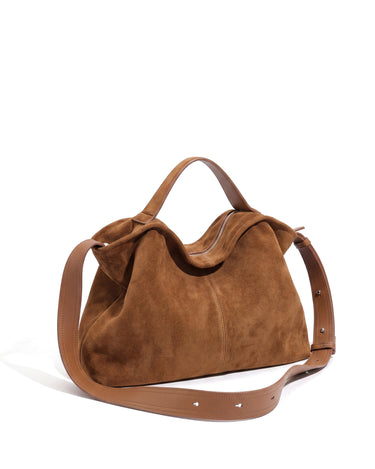 The Manon Suede Tote in tan, three-quarter studio view showing the slouched suede body and silver top zip