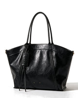 The Marais Carryall in black, front view on a pure white studio background showing the flared tote shape and whipstitched tag