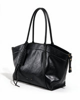 The Marais Carryall in black, three-quarter studio view showing the rolled twin straps and side zips
