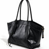 The Marais Carryall in black, three-quarter studio view showing the rolled twin straps and side zips