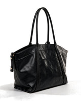 The Marais Carryall in black, rear view showing the plain back panel and side zips