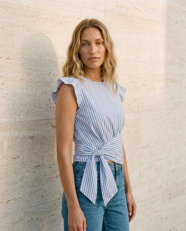 The Margot Tie Waist in blue and white stripe — side view showing tie waist bow on model
