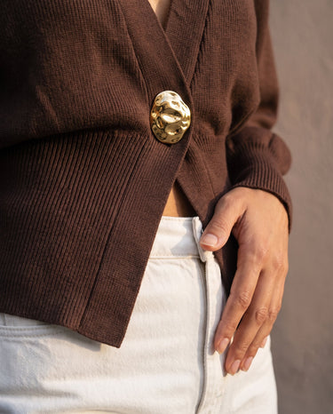 The Marley Cardigan in brown — close-up of the button and ribbed waist