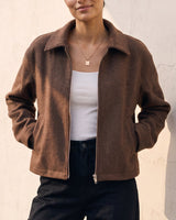 The Maude jacket in brown — front three-quarter view with hand in pocket on model