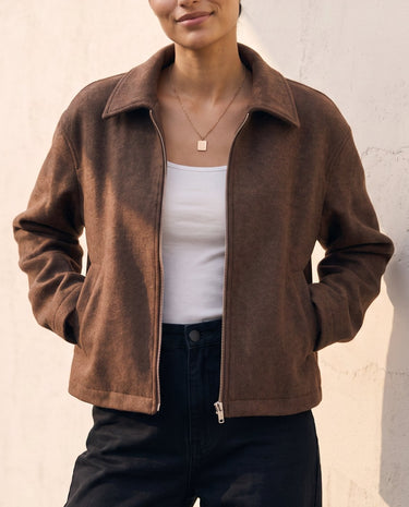 The Maude jacket in brown — front three-quarter view with hand in pocket on model